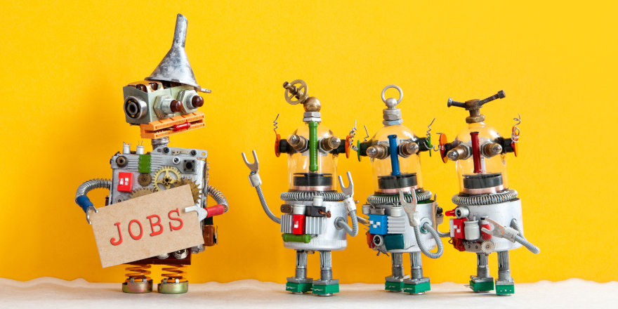Three little robots line up with a larger robot holding a 'Jobs' sign. Each of the wee bots is excited to be employed!